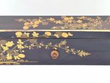 an image of a black and gold box with flowers on it