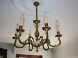 a chandelier in a room with a clock on the wall