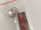 a small red object in a plastic bag on a white surface
