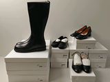 plusieurs paires de chaussures noires et blanches posées sur une pile de cartons