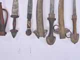 many different types of knives hanging on a wall