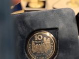 someone is holding a coin in their hand in front of a display case