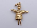 yellow gold plated pendant of a small doll with a hat on it ' s head