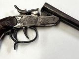 un pistolet posé sur une surface blanche