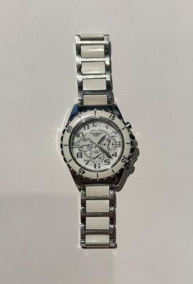 un gros plan d'une montre sur une surface blanche avec un fond blanc