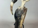 a close up of a sculpture of a bird on a stand