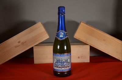 a bottle of wine sitting on a table next to a wooden box