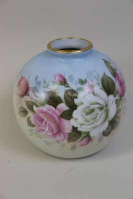 un vase bleu orné de fleurs roses et blanches