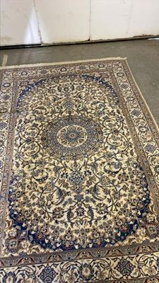 une photo montrant un grand tapis oriental posé sur le sol d'une pièce