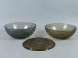 three glass bowls are sitting next to each other on a white surface
