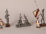 quatre figurines de soldats avec un drapeau et un mât