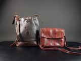 deux sacs marron et noirs posés sur une table noire