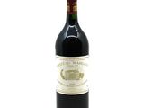 a bottle of red wine sitting on top of a white table