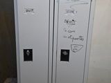 two white lockers with graffiti on them in a room