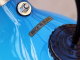 a close up of a blue motorcycle with a black handlebar