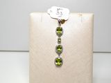 une image représentant une paire de boucles d'oreilles ornées de pierres vertes