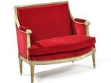 une image représentant une chaise rouge aux finitions dorées, avec un coussin rouge