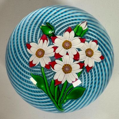 a blue and white vase with white flowers on it