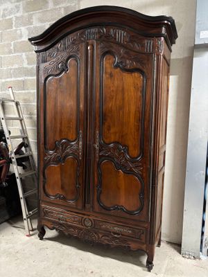 une armoire en bois avec des sculptures dans une pièce