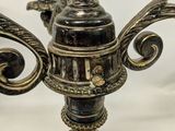 an image of a metal candelier with two candles on top of it