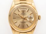 an image of a gold rolex watch on a white surface