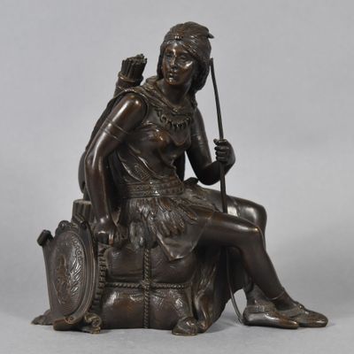 an image of a bronze statue of a woman sitting on a chair