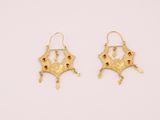 une paire de boucles d'oreilles en or ornées de pierres rouges