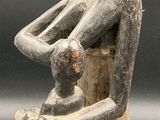 an image of a statue of a man sitting on a stool