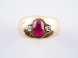 une image représentant une bague en or sertie d'un rubis et de deux diamants