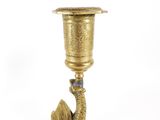 a gold colored candle holder with a bird on it