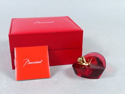une image représentant une boîte rouge contenant un flacon de parfum en forme de cœur rouge