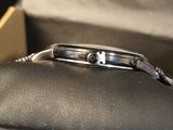 a black case with a silver watch inside of it