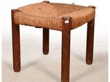 un petit tabouret en bois avec une assise tressée