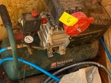 a green air compressor sitting on top of a wooden box