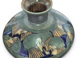 a green vase with a blue and yellow design on it