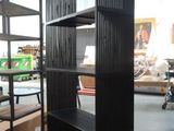 a black book shelf in the middle of a room