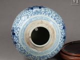 a blue and white vase sitting next to a wooden bowl