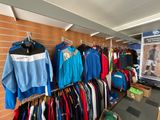 many shirts hanging on a rack in a store
