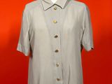 an image of a shirt on a mannequin stand against a red wall