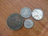 four different types of coins on a table with a wooden surface