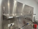 a stainless steel counter top with a sink and a shelf