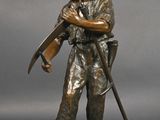 statue en bronze représentant un homme muni d'un pistolet et d'un fusil