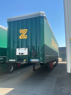 a large green semi truck parked in a parking lot