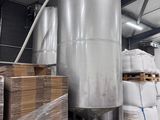 une grande cuve métallique posée au milieu d'un entrepôt