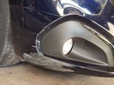 a close up of a car ' s front bumper with a hole in it
