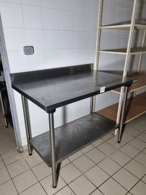 une table de travail en acier inoxydable équipée d'une étagère