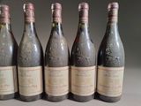 six bottles of wine are lined up in a row on a table