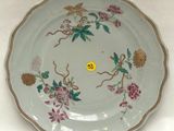 une assiette décorée de fleurs et d'oiseaux, posée sur une table