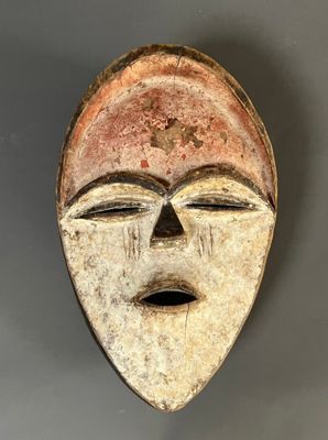 gros plan d'un masque en bois sur une surface grise