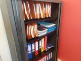 a bookshelf with a bunch of folders on top of it